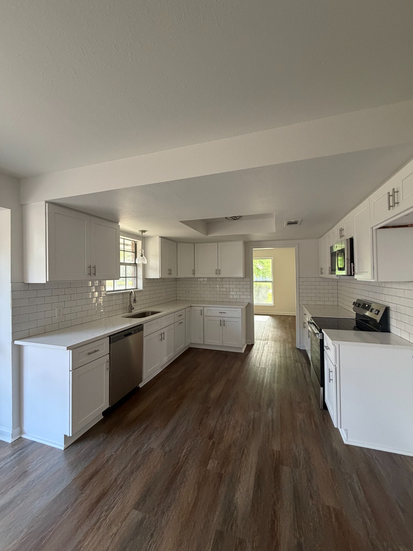 White kitchen cabinets and wood-look flooring